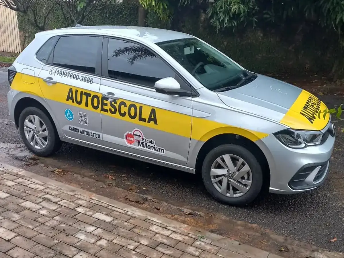 Carro automático da Millenium visto de frente e de lado, com o adesivo CARRO AUTOMÁTICO na porta